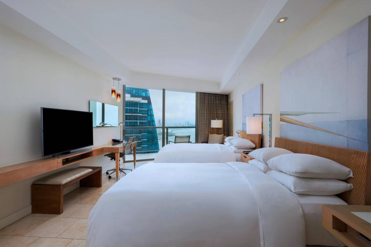 Guest room with 2 double beds, balcony and partial ocean view